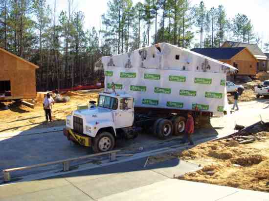 A moving truck transports a rescued home in Barrington Village.